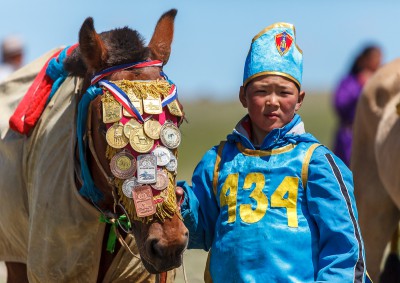 Fotoobraz - Syn trenéra E. Davánjama s vítězným koněm závodu během nádamu